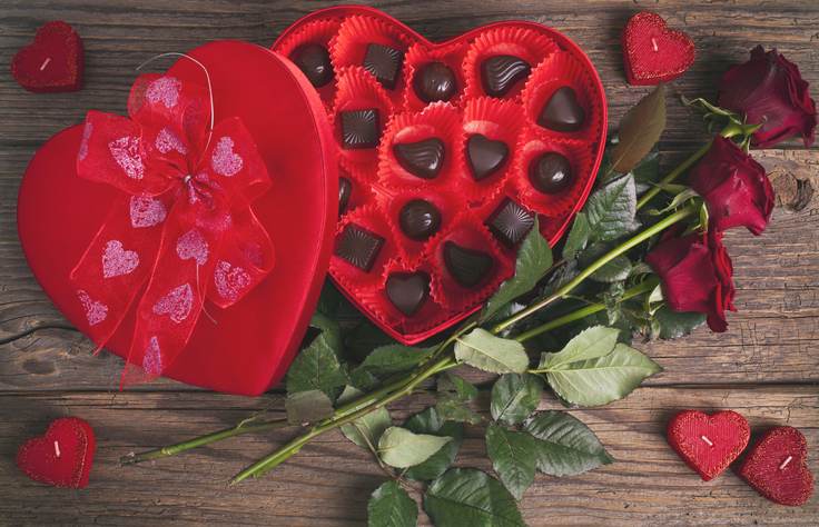 Heart chocolate box and red roses on wooden rustic background