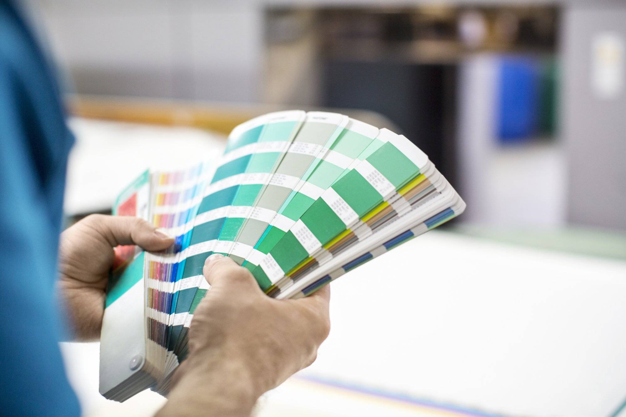 Man hands with colour samples at printing press